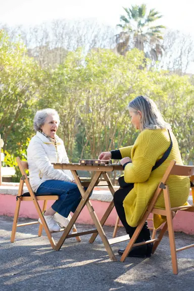 Two senior ladies playing chess in Wake Forest, NC as part of a recreational therapy program