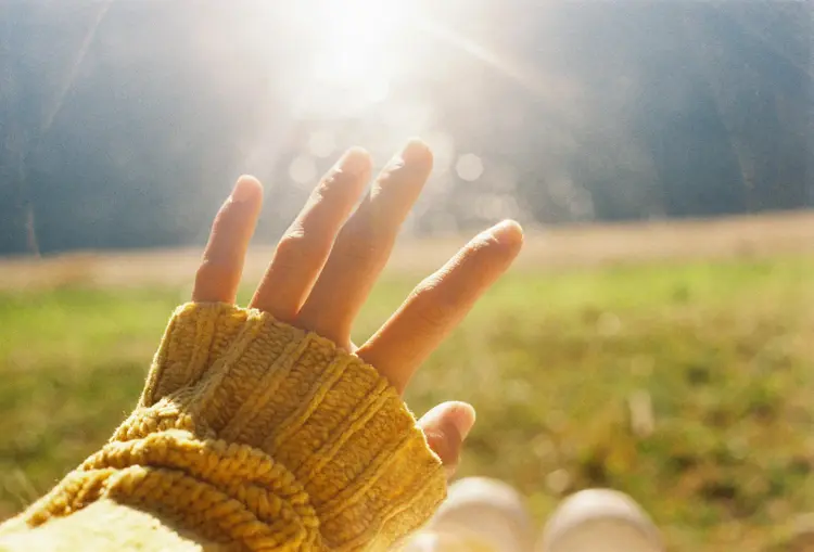 Hand reaching towards the sun, representing hope and recovery through Spravato therapy