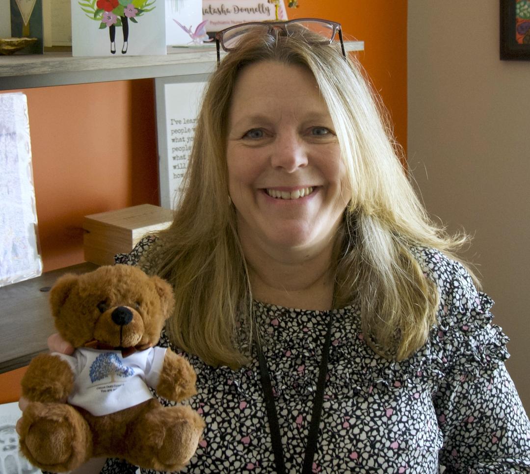 Cedar Oaks Clinic's recreational therapist Maddie Miller smiling with her dog Joan in Wake Forest, NC